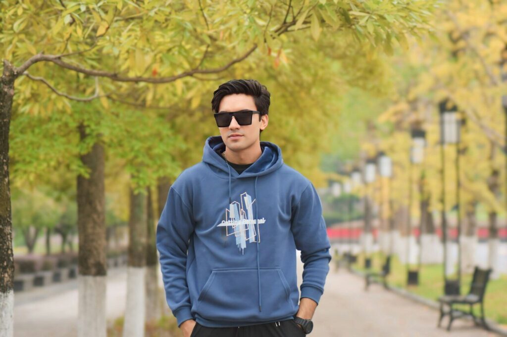 Man in sunglasses wearing blue hoodie in park