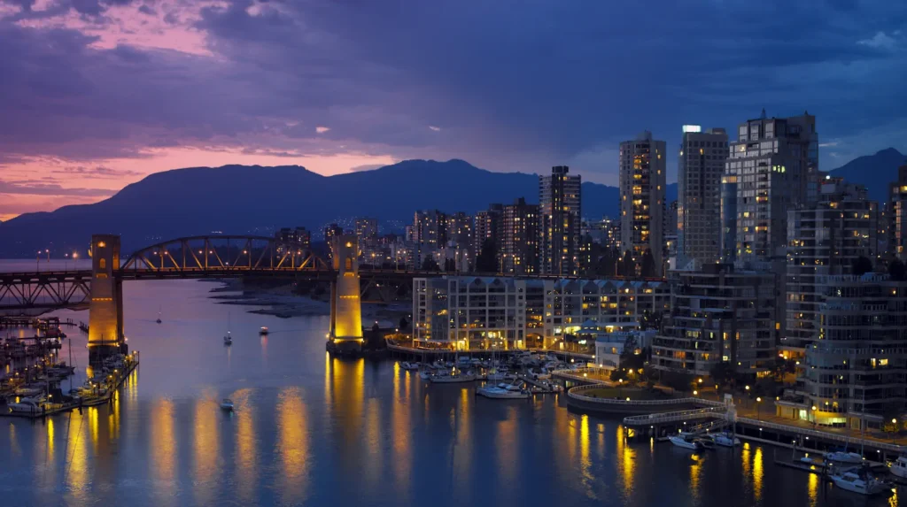 City skyline at dusk with bridge and marina